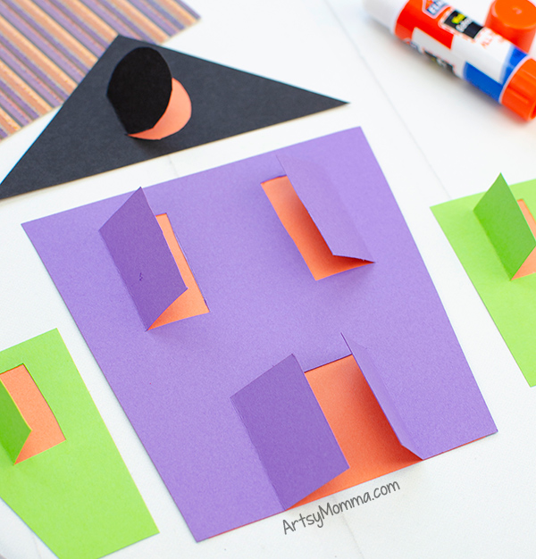 Haunted House Paper Craft with windows that appear to have the lights turned on