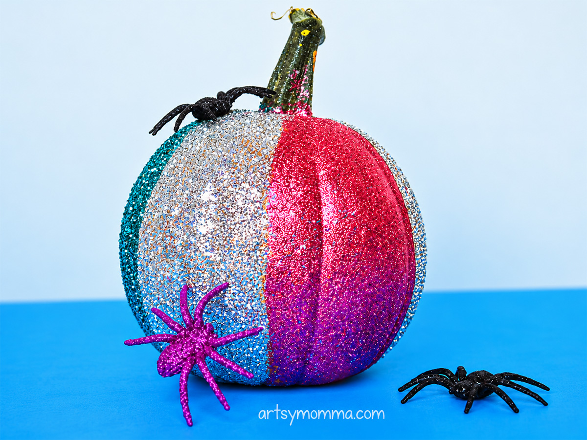 Fine glitter covering sections of real pumpkin in pink, teal, silver.