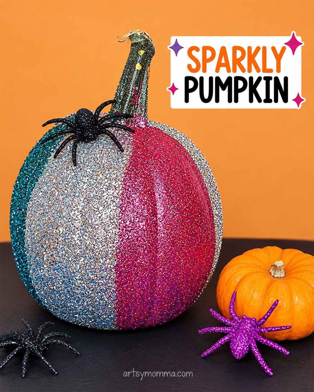 Pink, silver and turquoise DIY glitter pumpkin decorated with Halloween spiders